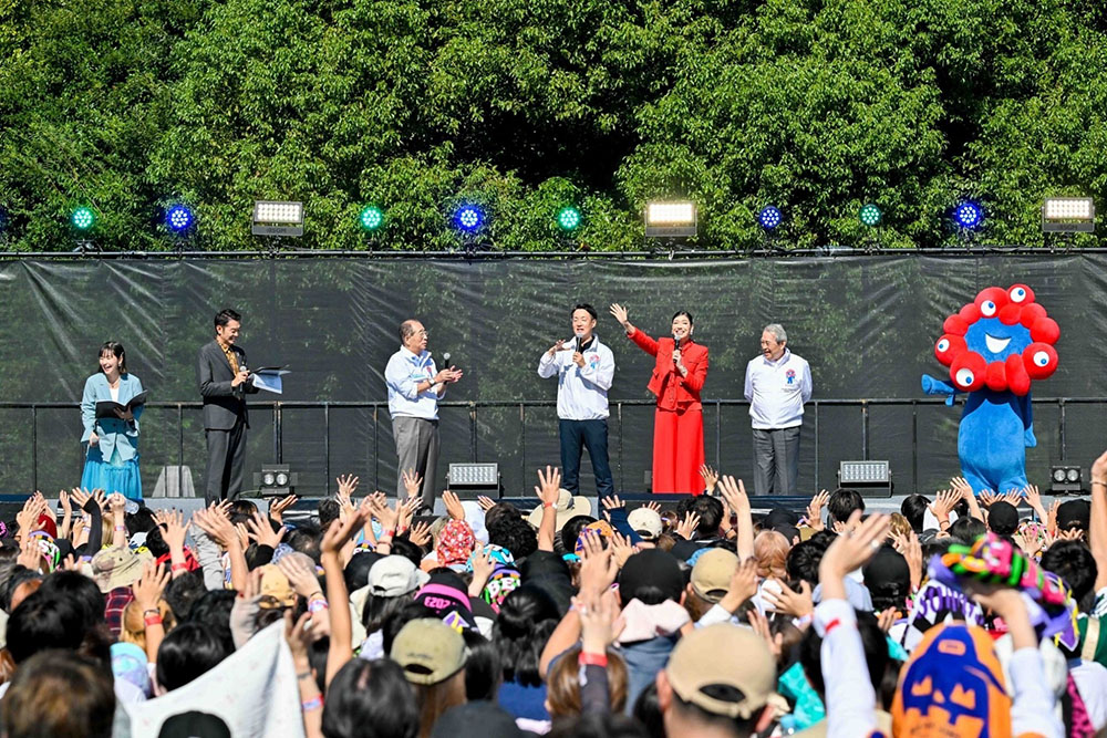 ステージ上の市長、松本正義会長、鳥井信吾会頭、赤いスーツのアン ミカ、ミヤクミャク